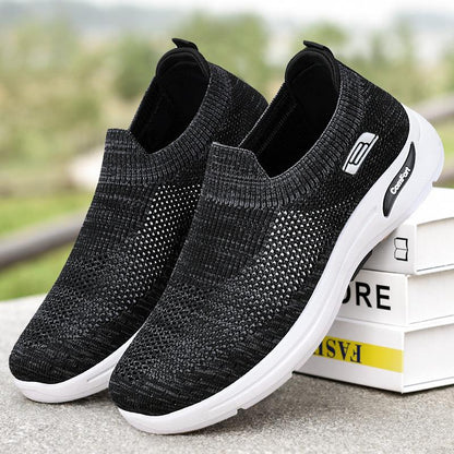 Black slip-on knit shoes with white sole and comfort logo patch