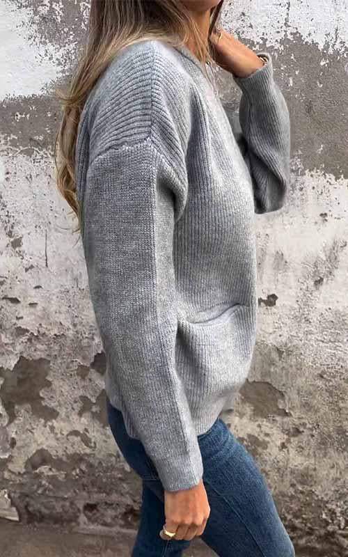 Grey zip-up knit cardigan with ribbed knit cuffs, front zipper, and patch pockets.