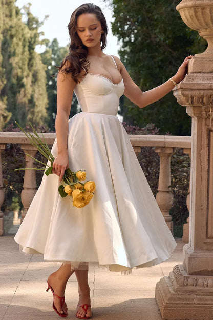 White satin midi dress with sweetheart bodice, spaghetti straps, and flared tulle skirt