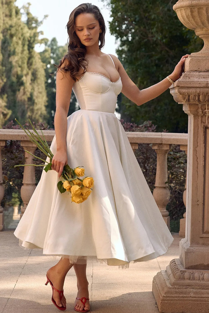 White satin midi dress with sweetheart bodice, spaghetti straps, and flared tulle skirt