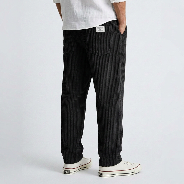 Black wide-leg corduroy pants with vertical ribbed texture and relaxed fit.