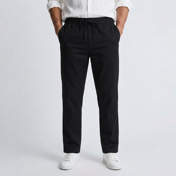 Black fluid linen pants with elastic drawstring waist and relaxed ankle-length fit