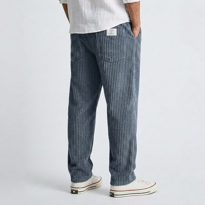 Wide dark blue corduroy pants with vertical ribbed texture and relaxed straight leg