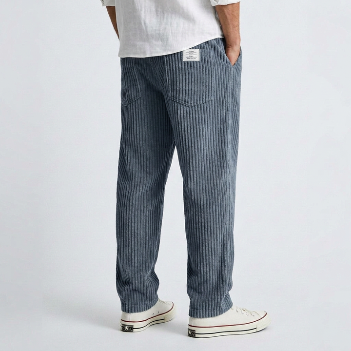Wide dark blue corduroy pants with vertical ribbed texture and relaxed straight leg