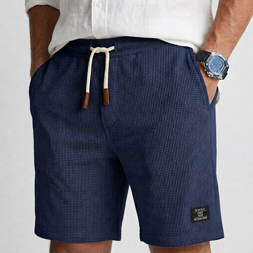Dark blue textured knit casual shorts with elastic waist, drawstring, and side patch