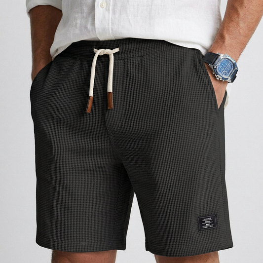 Black textured knit casual shorts with elastic waistband and drawstring, side label patch