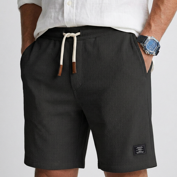 Black textured knit casual shorts with elastic waistband and drawstring, side label patch
