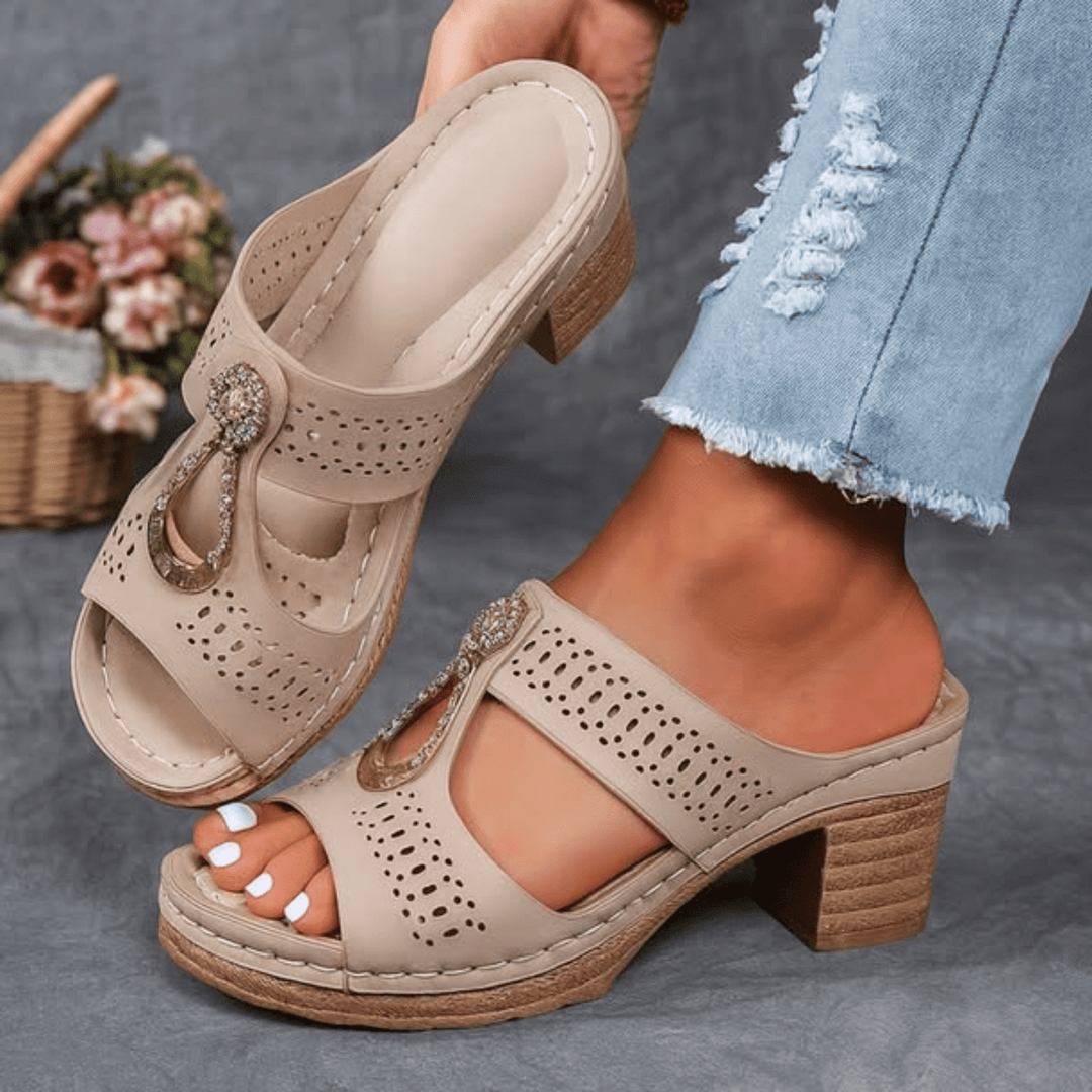 Beige orthopedic sandals with perforated straps, jeweled buckle, and mid block heel