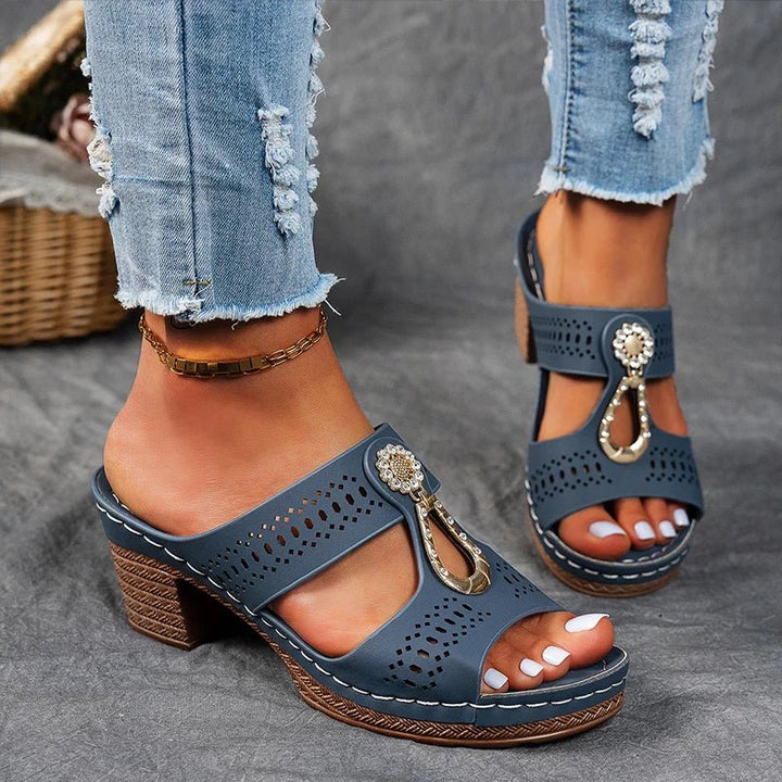 Navy blue orthopedic sandals with perforated straps, jeweled buckle, and block heel