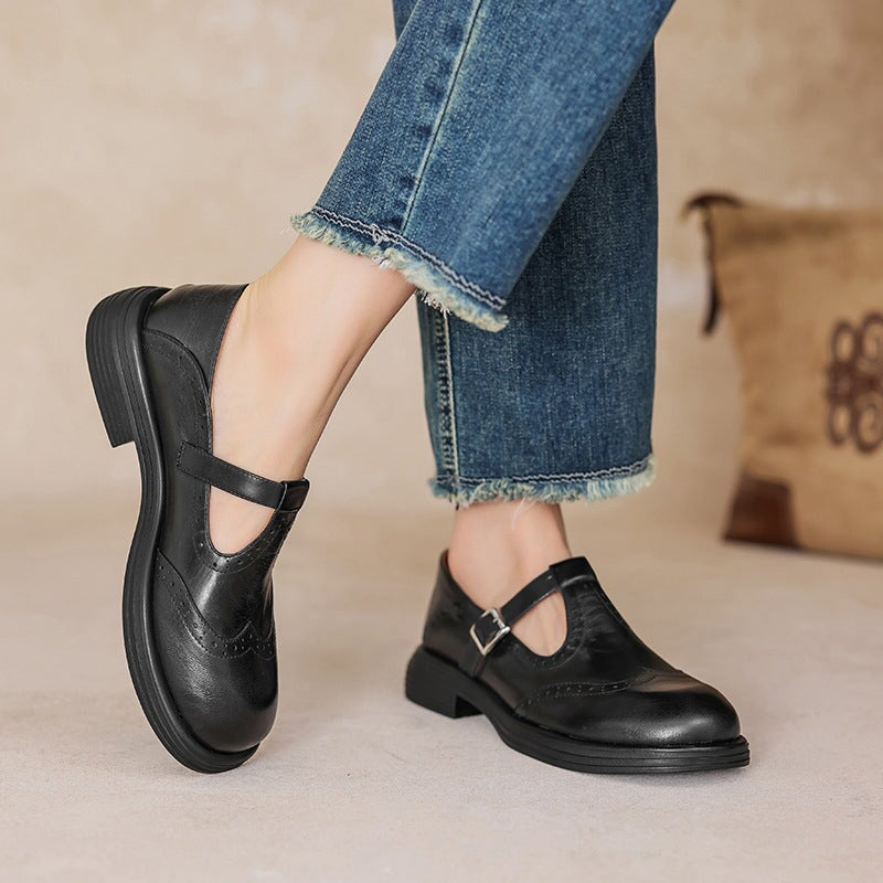 Black leather Mary Jane flats with buckle strap and low block heel.