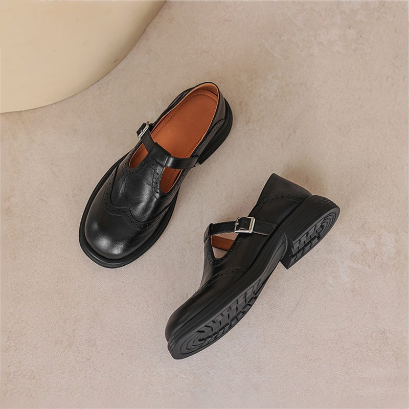 Black leather Mary Janes with buckle strap, showing side view and tread sole.
