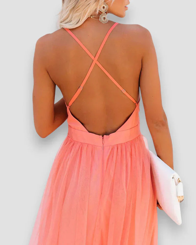 Coral pink open-back maxi dress with crisscross halter straps and gathered waist