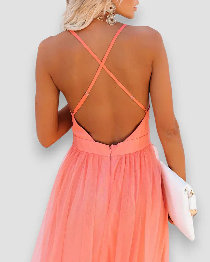 Coral pink open-back maxi dress with crisscross halter straps and gathered waist