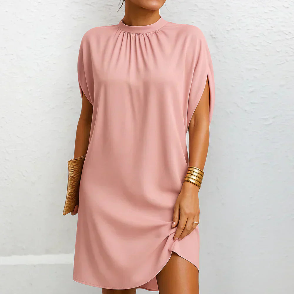 Pink mini dress with high neck, gathered yoke, cape sleeves, and side slit