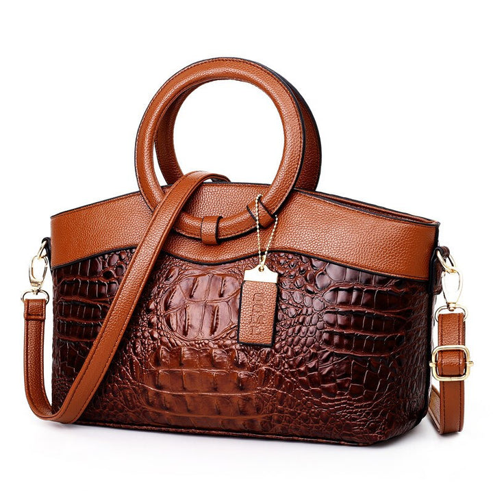 Brown and dark brown croc-textured women’s handbag with top handles and crossbody strap