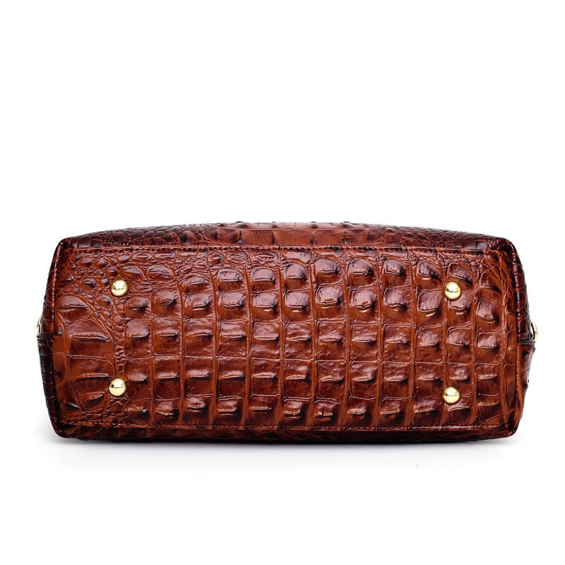 Brown croc-textured handbag with gold-tone studs and ribbed panel detailing