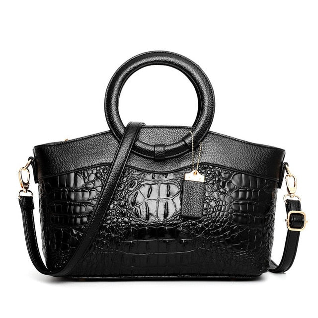 Black croc-textured women’s handbag with top handles and crossbody strap