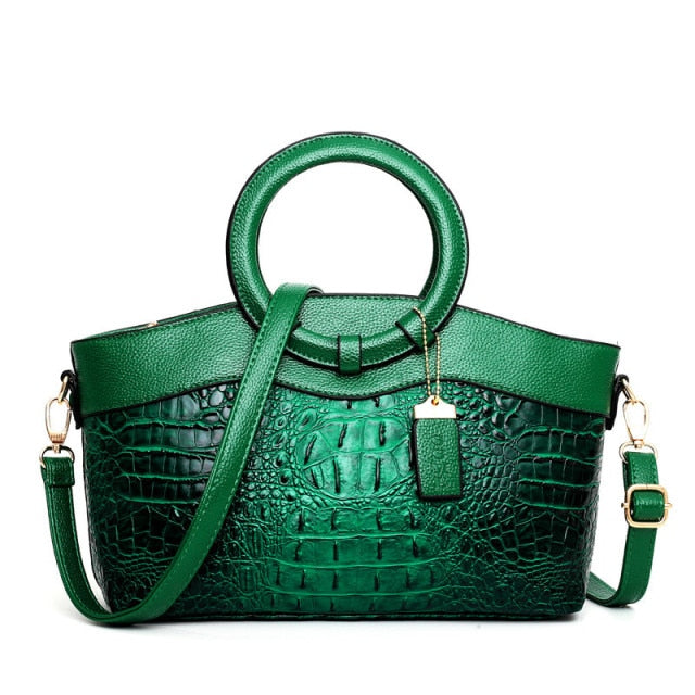 Green croc-textured women’s handbag with top handles and crossbody strap