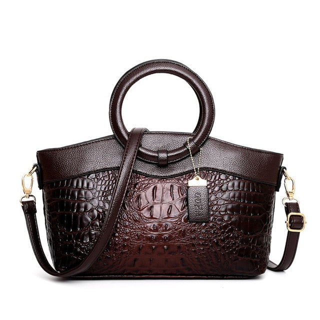 Dark brown croc-textured women’s handbag with top handles and adjustable crossbody strap