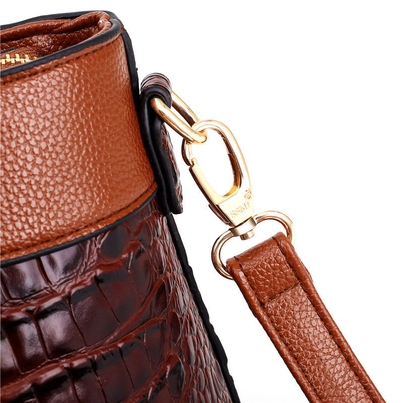 Brown handbag with gold-tone clasp and leather keyring strap detail close-up.
