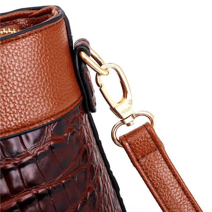 Brown handbag with gold-tone clasp and leather keyring strap detail close-up.