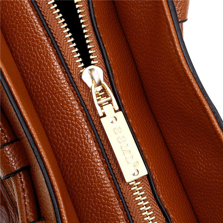 Brown handbag with top zipper and gold-tone zipper pull in textured leather.