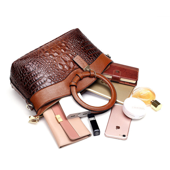 Brown croc-textured handbag with top handles and side clasp detail