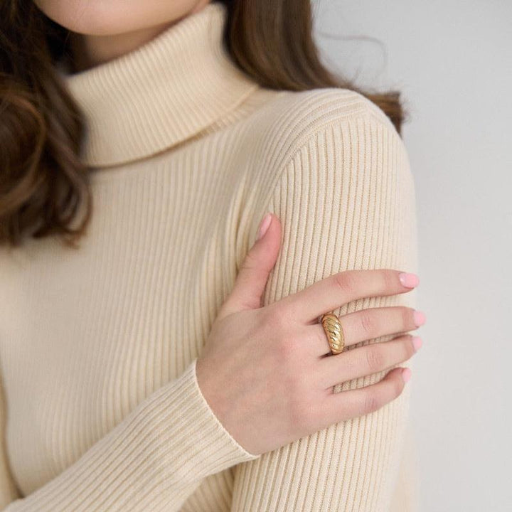 Cream ribbed turtleneck sweater with long sleeves and a snug high neckline