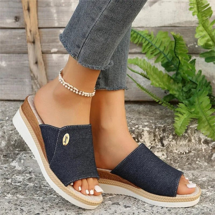 Dark navy denim ergonomic sandals with open toe and tan espadrille-style sole trim