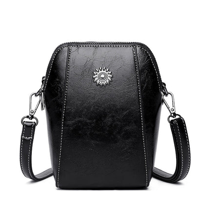Black mini crossbody handbag with zipper and sunburst emblem