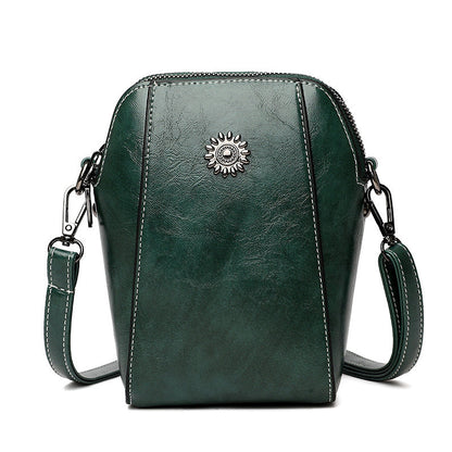 Green mini crossbody handbag with zipper and sunburst emblem