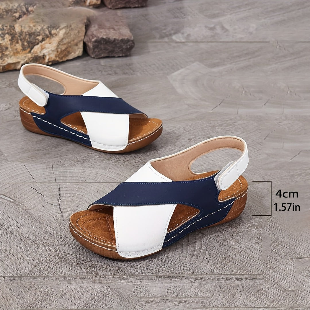 Ergonomic sandals in white and navy with curved hook straps and tan platform sole