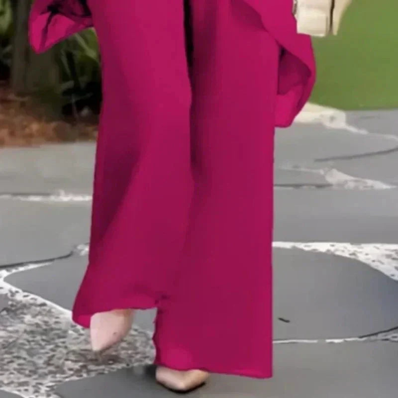 Pink wide-leg trousers with layered side detail, part of a two-piece set