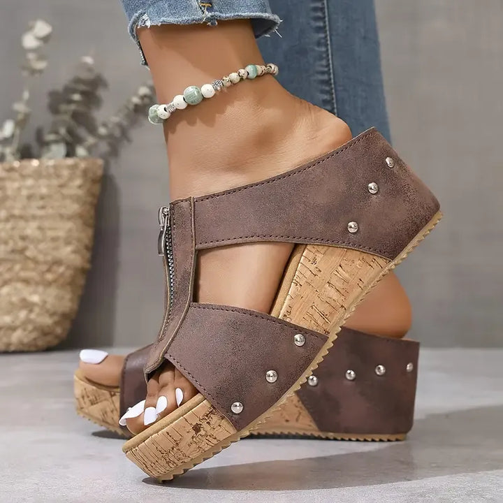 Brown wedge sandals with ankle strap, stud accents, and cork-look platform sole