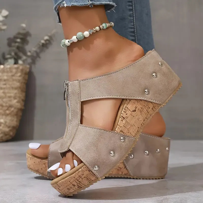 Beige wedge sandals with ankle zip, stud accents, and cork-look platform sole