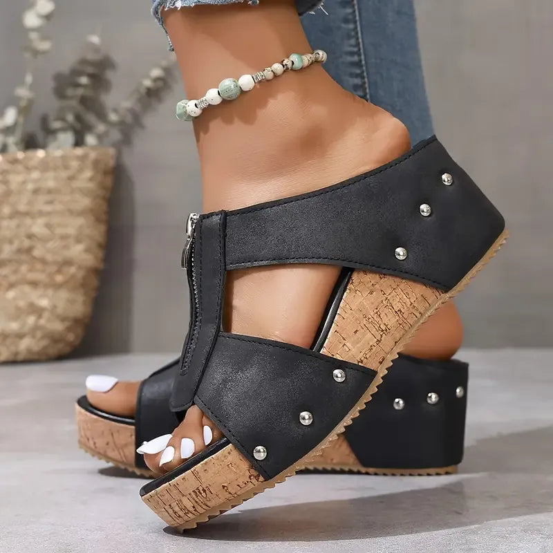 Black wedge sandals with ankle strap, stud accents, and cork-look platform sole