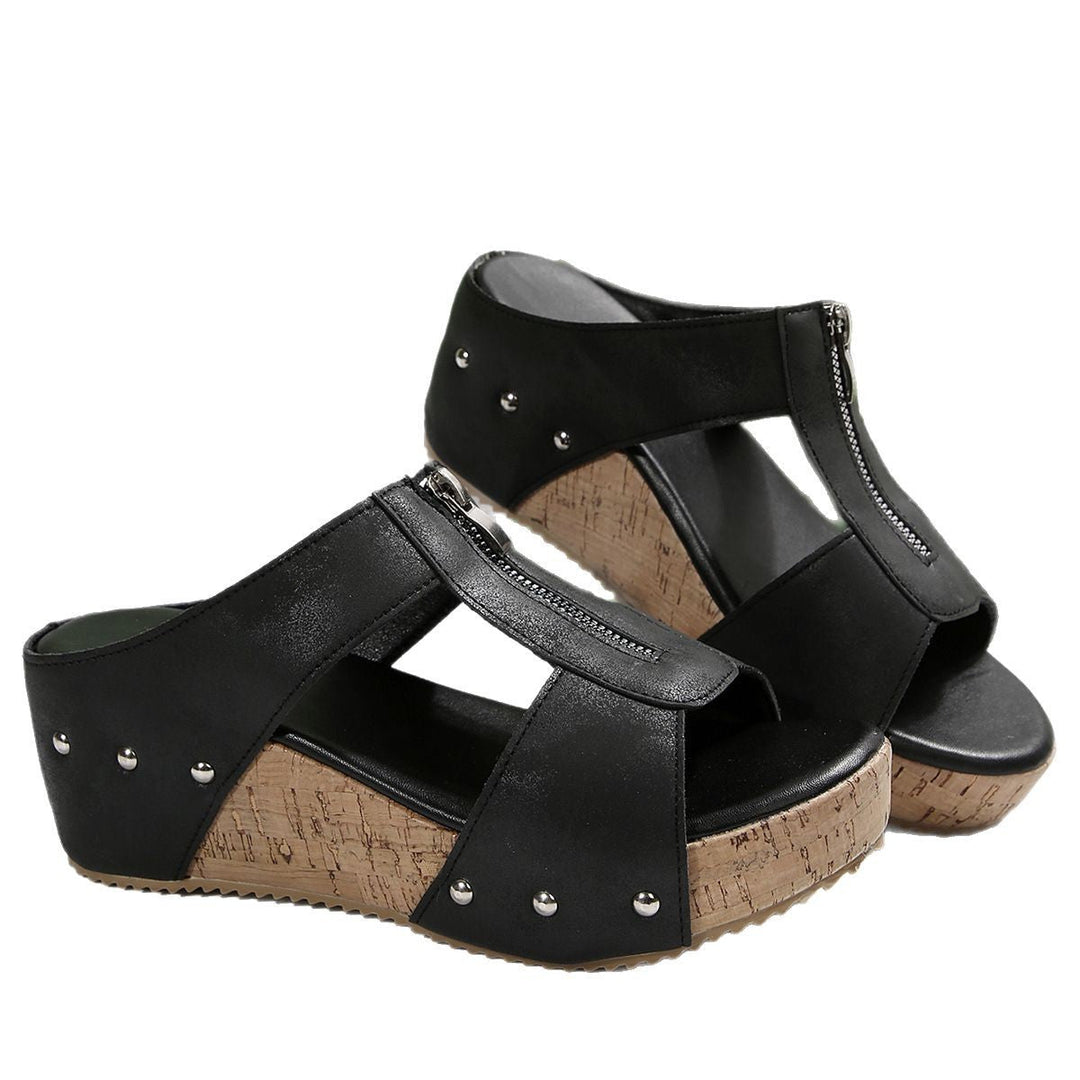 Black wedge sandals with ankle strap, stud details, open toe, and cork-look platform