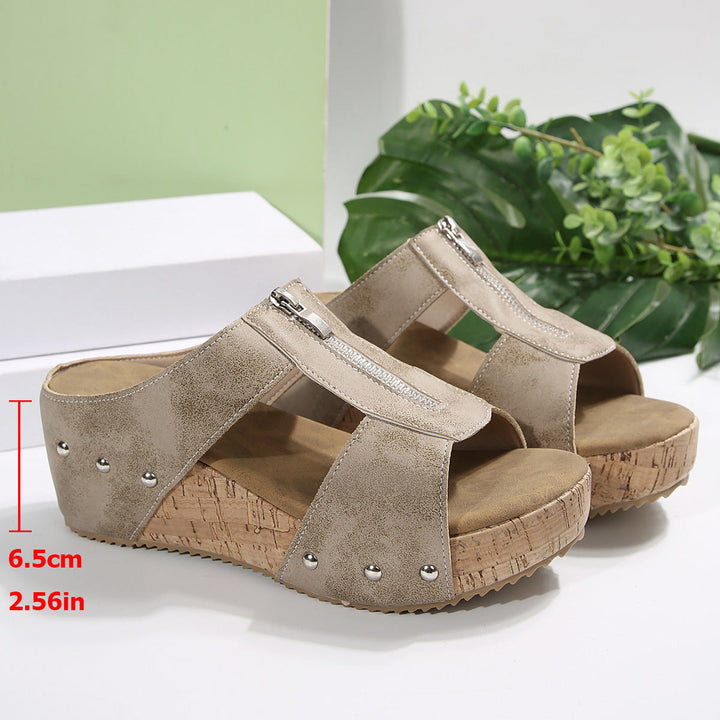Beige wedge sandals with ankle strap, stud details, open toe, and cork-look platform