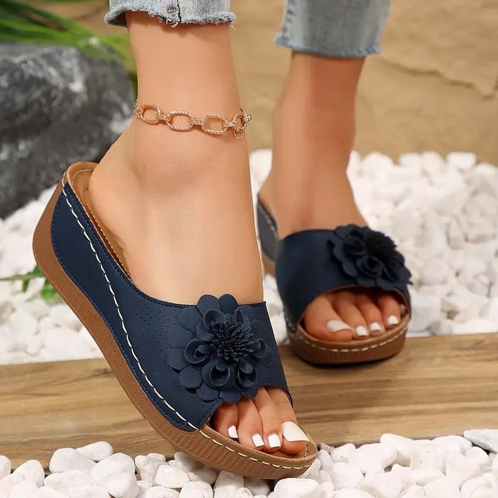 Navy ergonomic sandals with front flower detail and open toe, tan sole