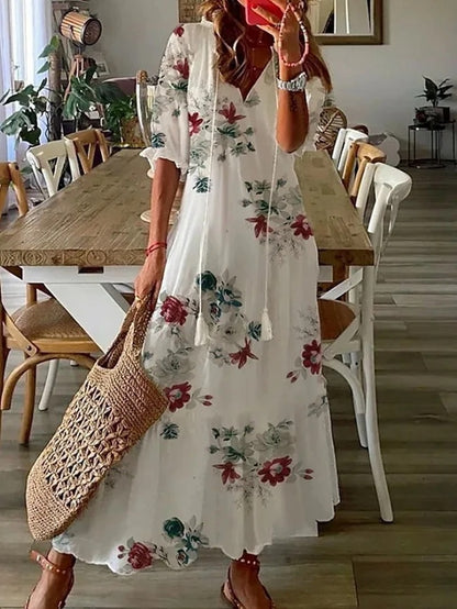 Loose bohemian dress in white with red and green floral print, loose maxi length