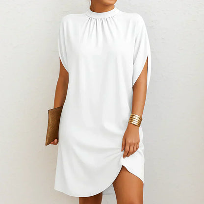 White mini dress with high neck and gathered yoke, cape sleeves, and side slit
